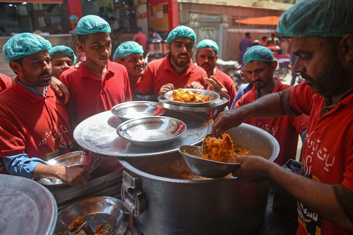 A staff serves plates of biryani at a restaurant in Karachi. — AFP