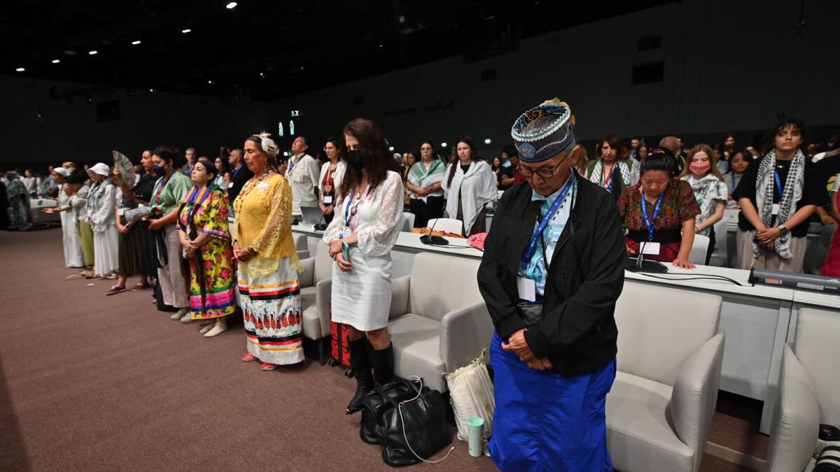 Attendees stand for a minute of silence in support of those killed in Gaza during the People's Plenary at the United Nations Climate Conference (COP28) at Expo City in Dubai. — AFP