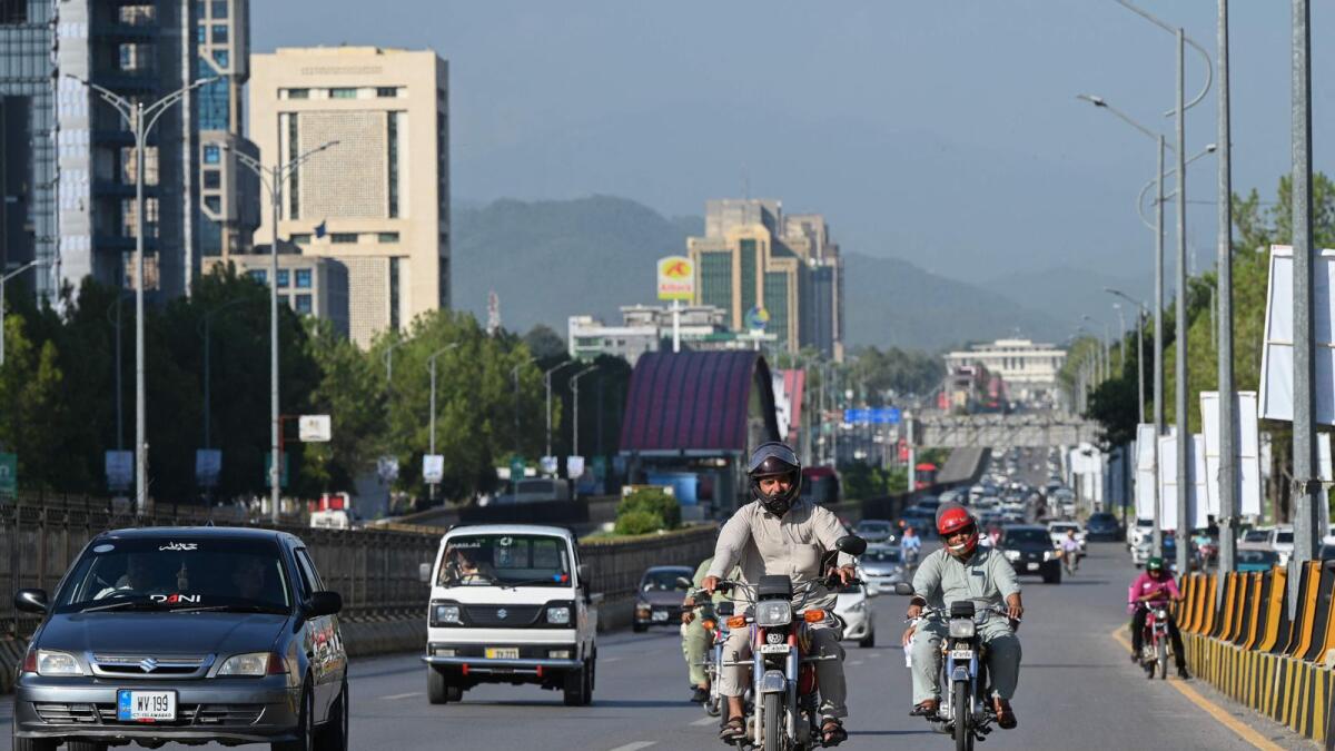 People commute on a road in Islamabad on July 11, 2023. Under the bailout deal, the IMF also got Pakistan to raise $1.34 billion in new taxation to meet fiscal adjustments. —AFP