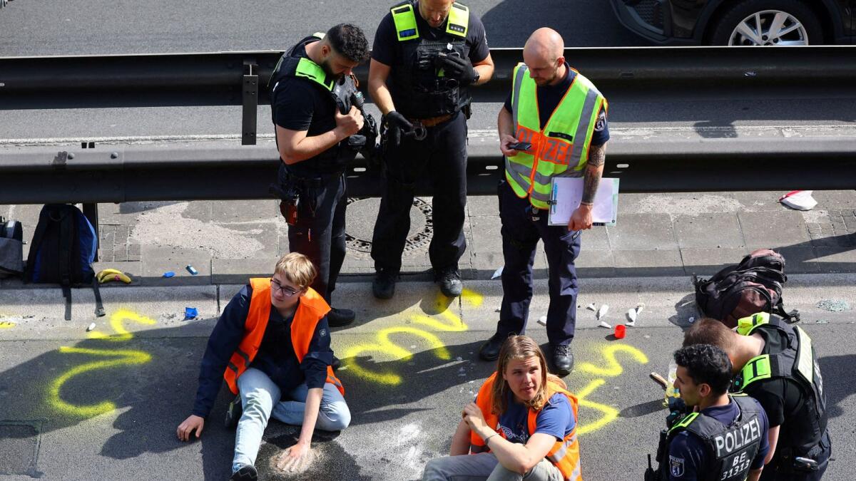 Police surround activists of the 'Letzte Generation' (Last Generation) after they glued their hands on asphalt, while blocking the central highway A100 to protest for climate councils, a speed limit on highways as well as for affordable public transport in Berlin, Germany, on May 22. — Reuters