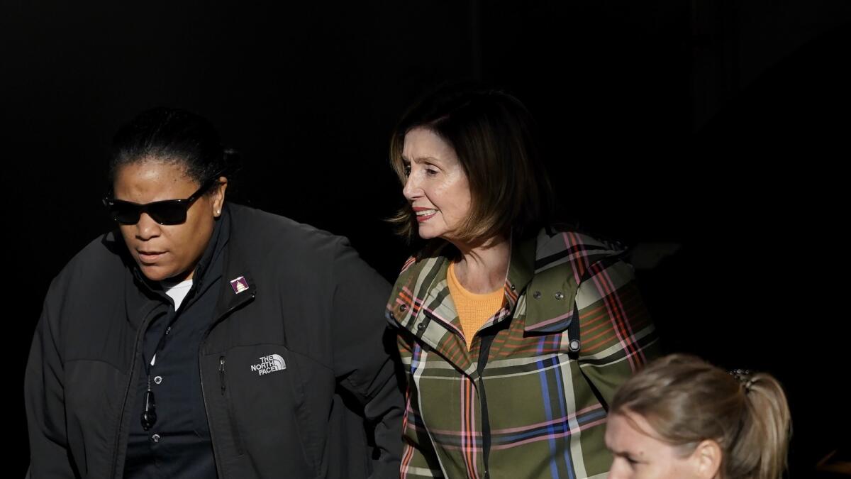 House Speaker Nancy Pelosi is escorted to a vehicle outside of her and husband Paul Pelosi's home in San Francisco on Nov. 2, 2022. — AP