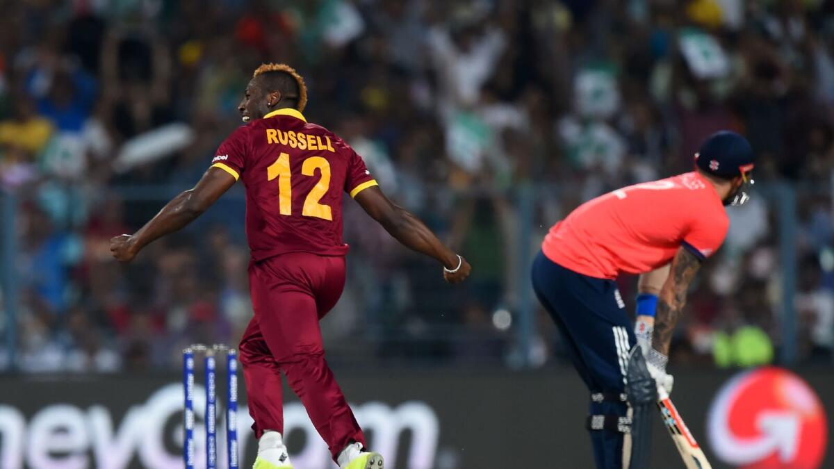 West Indies's Andre Russell(L)celebrates after the dismissal of England's Alex Hales during the World T20 cricket tournament final match between England and West Indies at The Eden Gardens Cricket Stadium in Kolkata on April 3, 2016.
