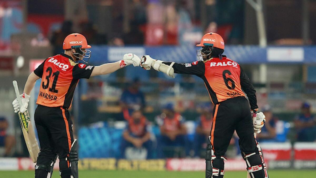 Sunrisers Hyderabad captain David Warner (left) fist bumps Wriddhiman Saha during the match against the Mumbai Indians in Sharjah on Tuesday night. — BCCI/IPL