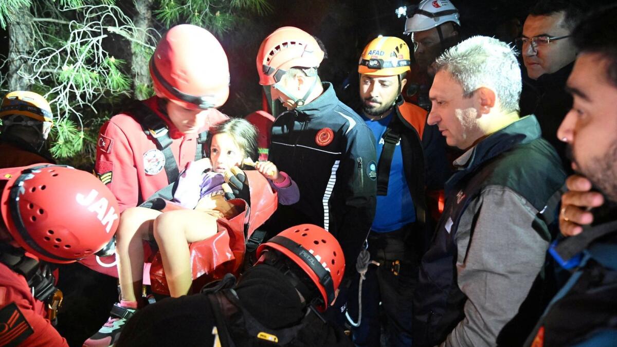 A girl is carried by a member of Gendarmerie Search and Rescue (JAK) team during a rescue operation after a cable car cabin collided with a broken pole, in Antalya, Turkey on Friday. Photo: Reuters