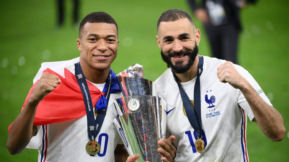 France's Kylian Mbappe (left) and Karim Benzema celebrate with the trophy at the end of the Nations League final against Spain. (AFP)
