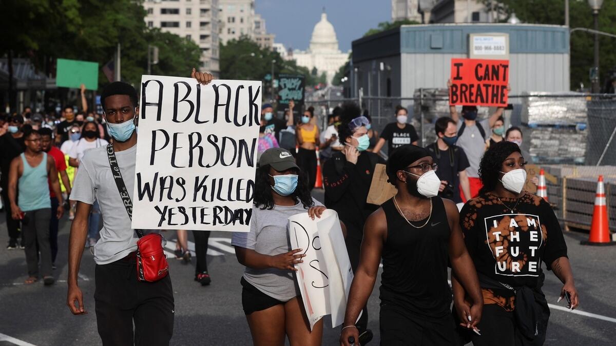 Protesters wearing face masks attend an 'I can't breathe' vigil and rally following the death of African-American George Floyd who was seen in graphic video footage gasping for breath as a white officer knelt on his neck in Minneapolis, Minnesota, in Washington, U.S., May 29, 2020.