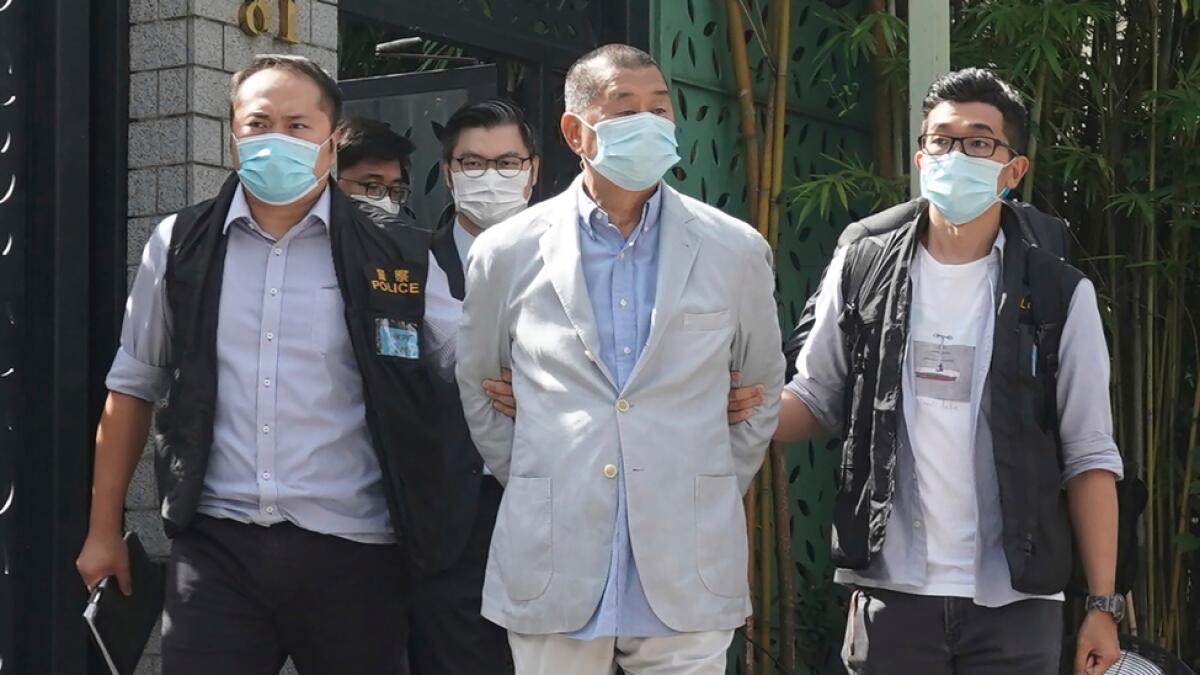 Hong Kong media tycoon Jimmy Lai, centre, who founded local newspaper Apple Daily, is arrested by police officers at his home in Hong Kong, on Monday. Hong Kong police arrested Lai and raided the publisher's headquarters on Monday in the highest-profile use yet of the new national security law Beijing imposed on the city after protests last year. Photo: AP