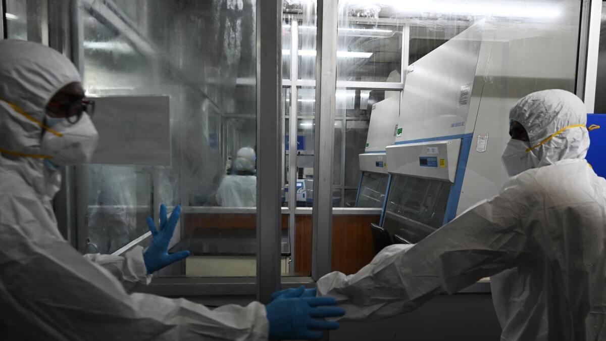 Technicians wearing personal protective equipment (PPE) suits are seen inside a molecular laboratory facility set up to test for the monkeypox disease. Photo: AFP