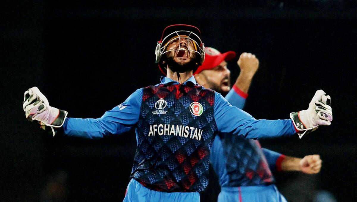 Afghanistan's Ikram Alikhil celebrates after Rashid Khan bowls out England's Mark Wood to win the match. Photo: Reuters