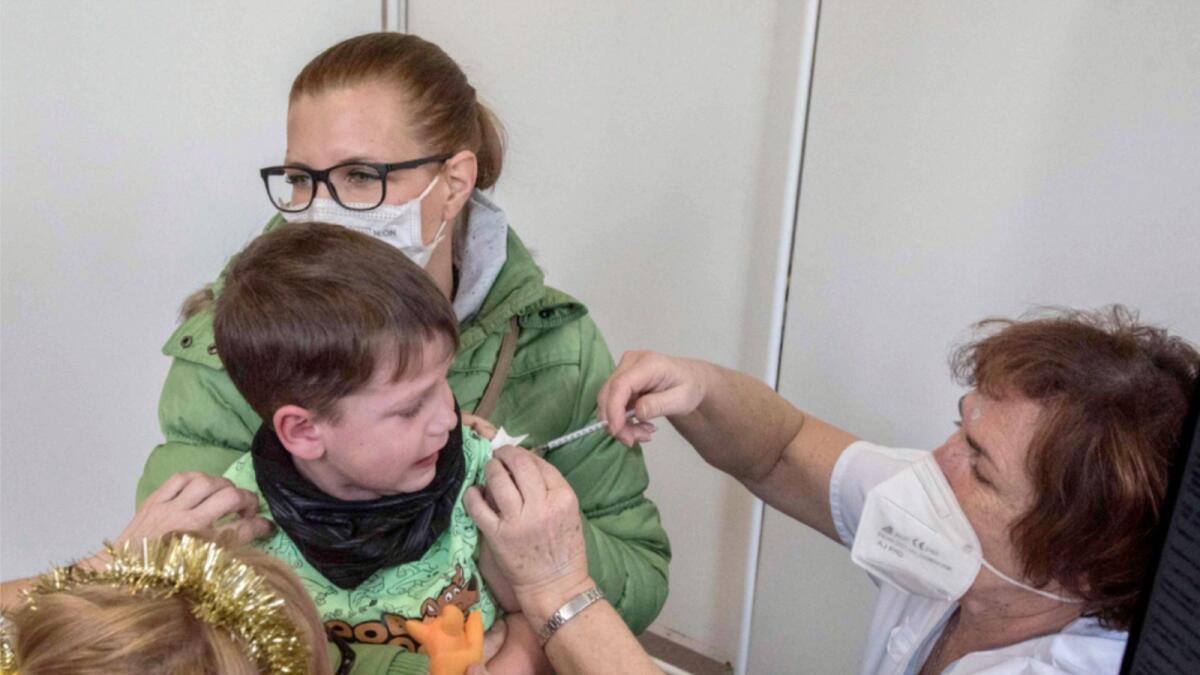 A child receives the Covid vaccine in Prague. — AFP