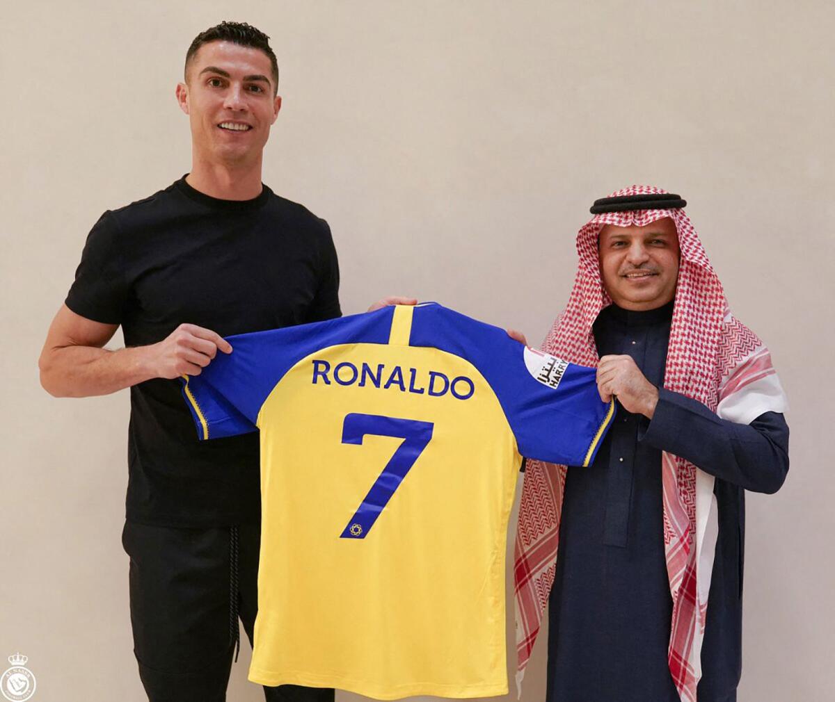 Portugal's Cristiano Ronaldo presented with the Al Nassr club's number seven jersey by club president Musalli Al-Muammar in Madrid. — AFP