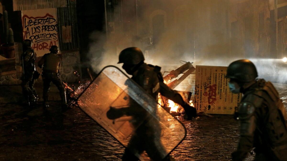 Security forces are seen near a burning barricade during a protest against the Pension Funds Administration, after a congressional session on a pensions reform, amid the spread of the coronavirus disease (Covid-19) in Valparaiso, Chile. Photo: Reuters