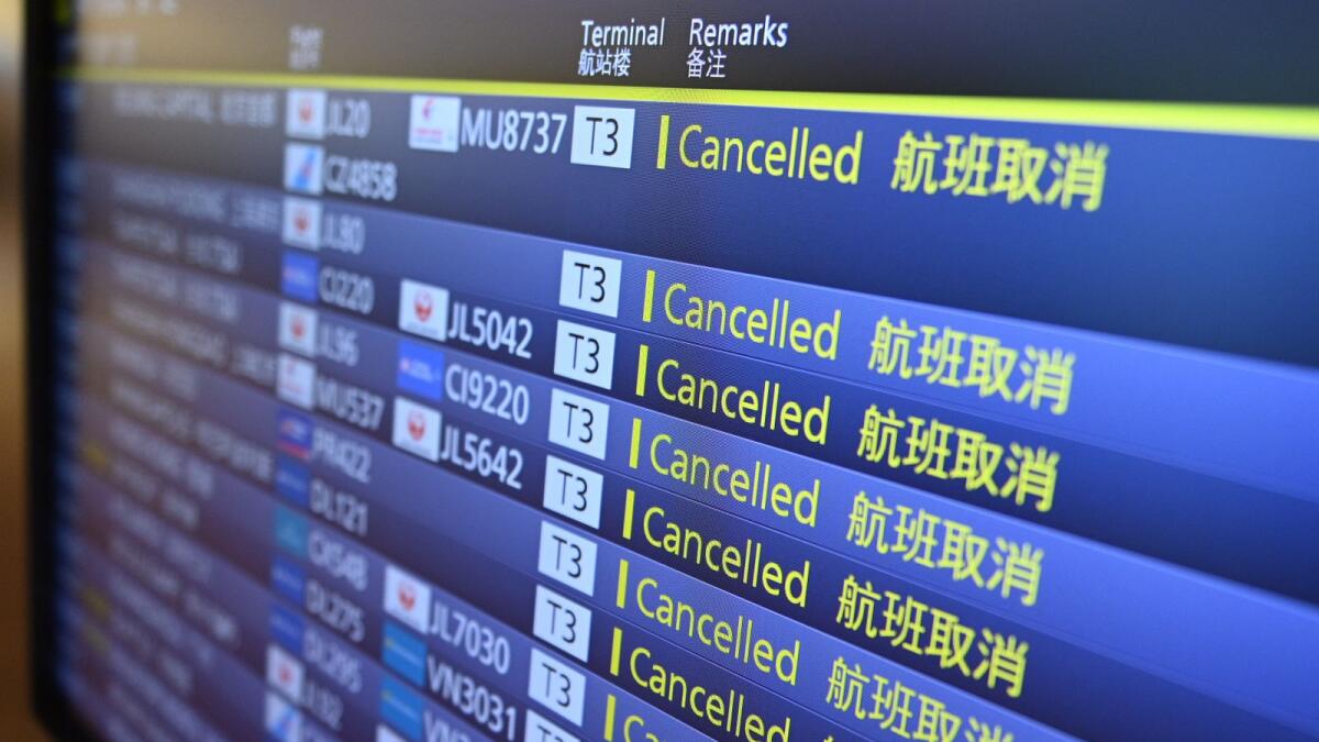 File image. A board displays cancelled flights at Tokyo's Haneda airport. Photo: AFP