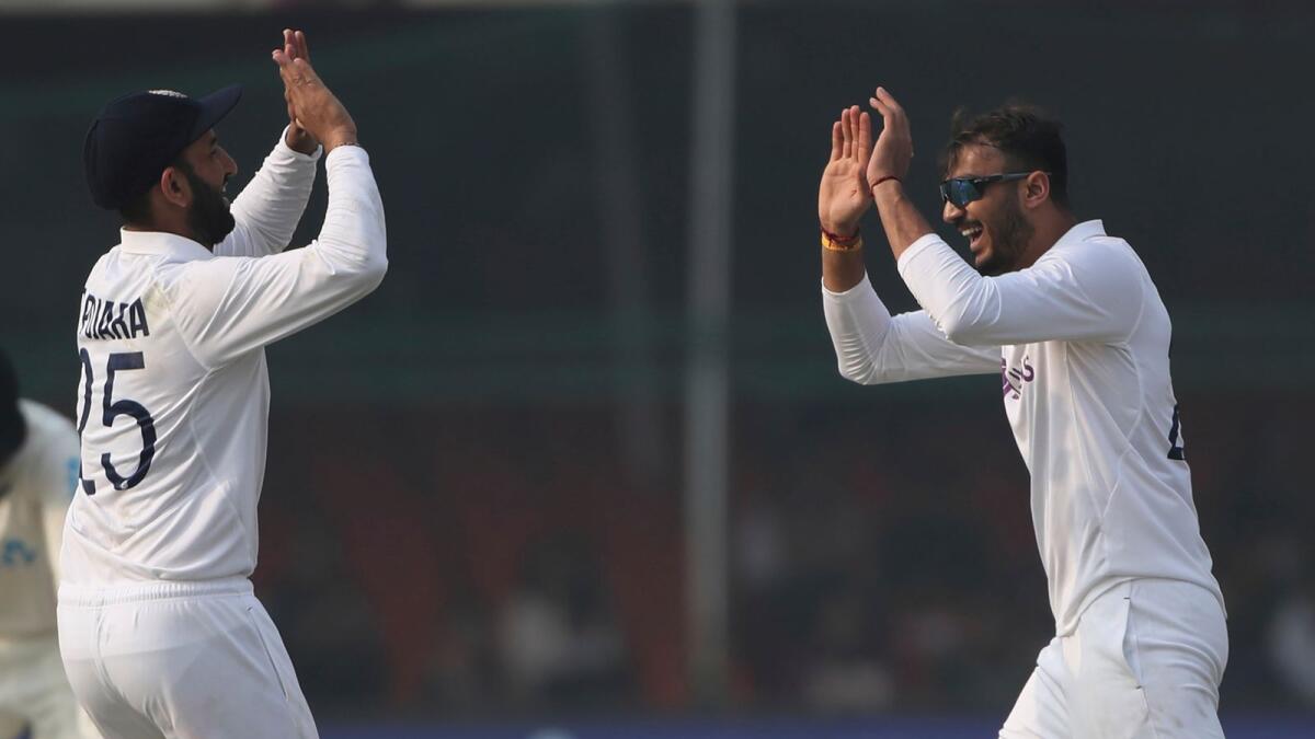 India's bowler Axar Patel (right) celebrates the dismissal of New Zealand's Tom Blundell with his teammate Cheteshwar Pujara. (AP)