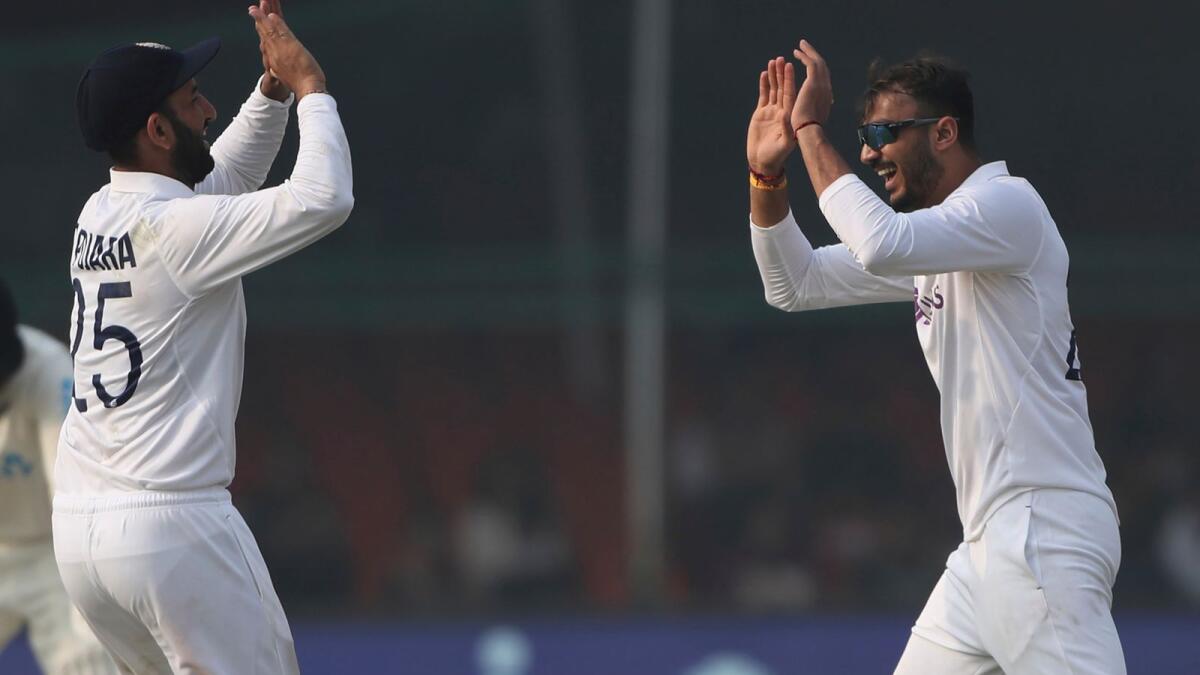 India's bowler Axar Patel (right) celebrates the dismissal of New Zealand's Tom Blundell with his teammate Cheteshwar Pujara. (AP)