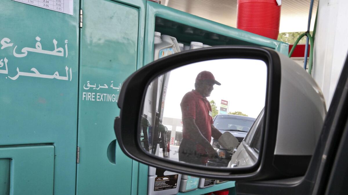 A gas attendant filling up a gas tank of a car at Emirates Hills petrol station in Dubai.-Photo by Leslie Pableo/ Khaleej Times