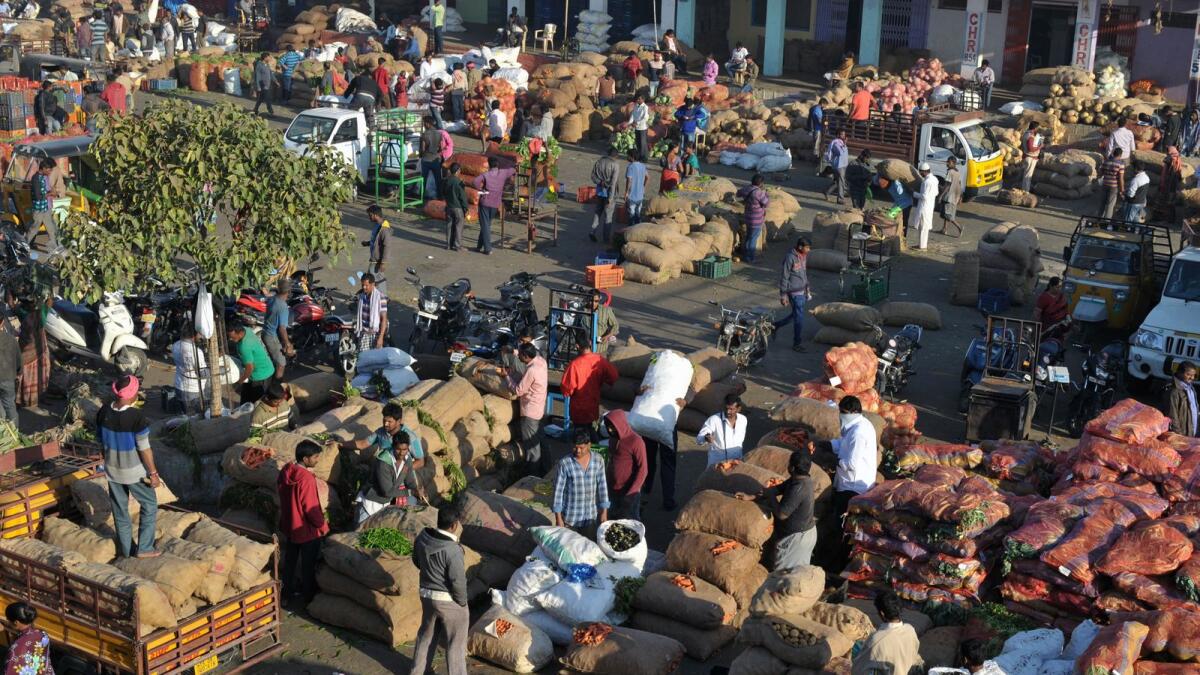 Indian farmers, traders and vendors negotiate prices of vegetables at a wholesale vegetable market in Hyderabad - AFP