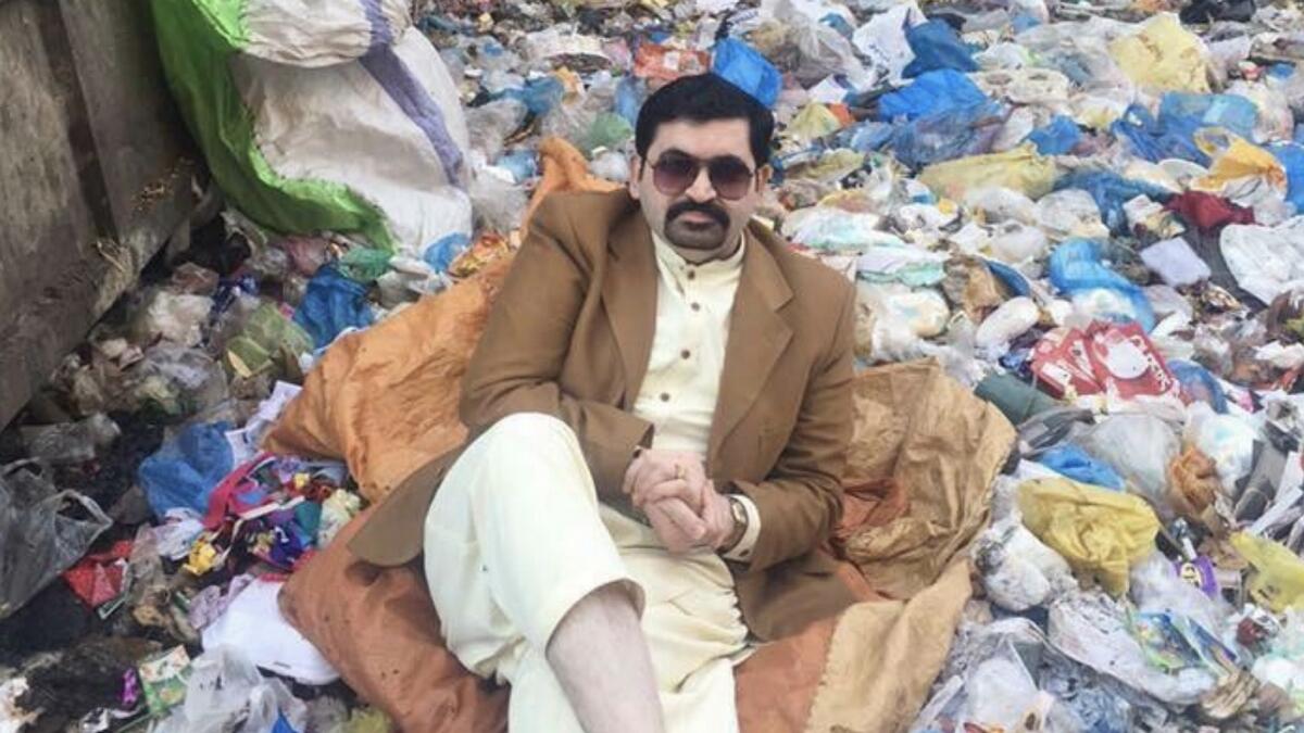 Pakistani politician sits in garbage dump to ask for votes