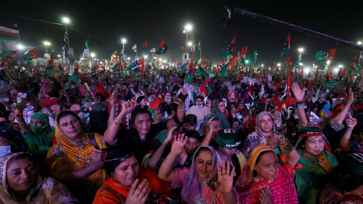 Female supporters of Pakistan Democratic Movement (PDM), an alliance of political opposition parties, react to party songs during an anti-government protest rally in Karachi, Pakistan October 18, 2020.