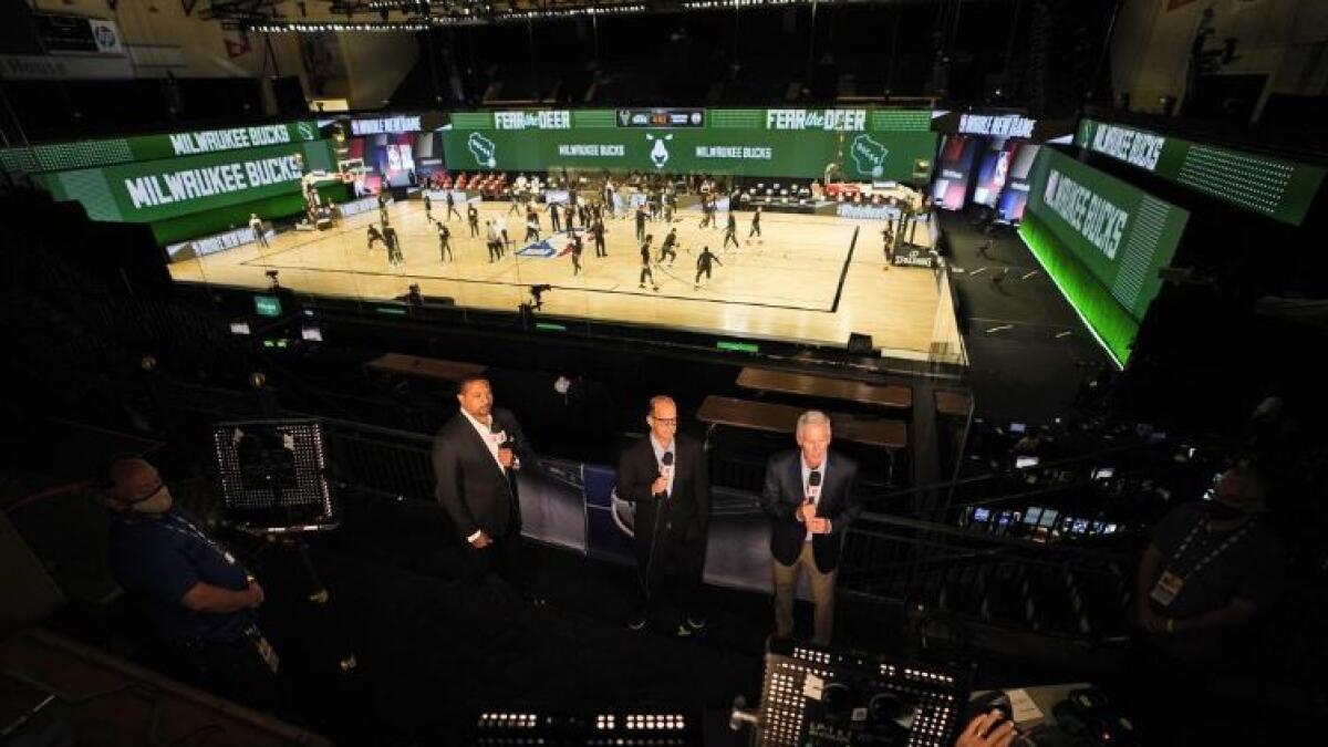 Commentators are seen in the stands as players warm up before the start of an NBA game between the Milwaukee Bucks and the Boston Celtics on Friday. (Reuters)