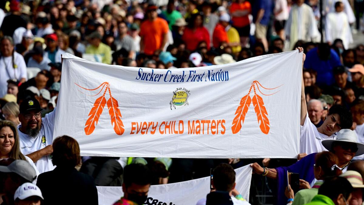 People display a banner reading 'Sucker Creek First Nation Every Child Matters' as Pope Francis arrives for an open-air mass at Commonwealth Stadium in Edmonton, Canada, on July 26, 2022. Photo: AFP