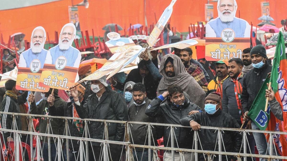 BJP supporters hold chairs and cut-outs with portrait of BJP leader and India's Prime Minister Narendra Modi as they await his arrival during a rally ahead of the state assembly elections in Ferozepur on January 5, 2022. Photo: AFP