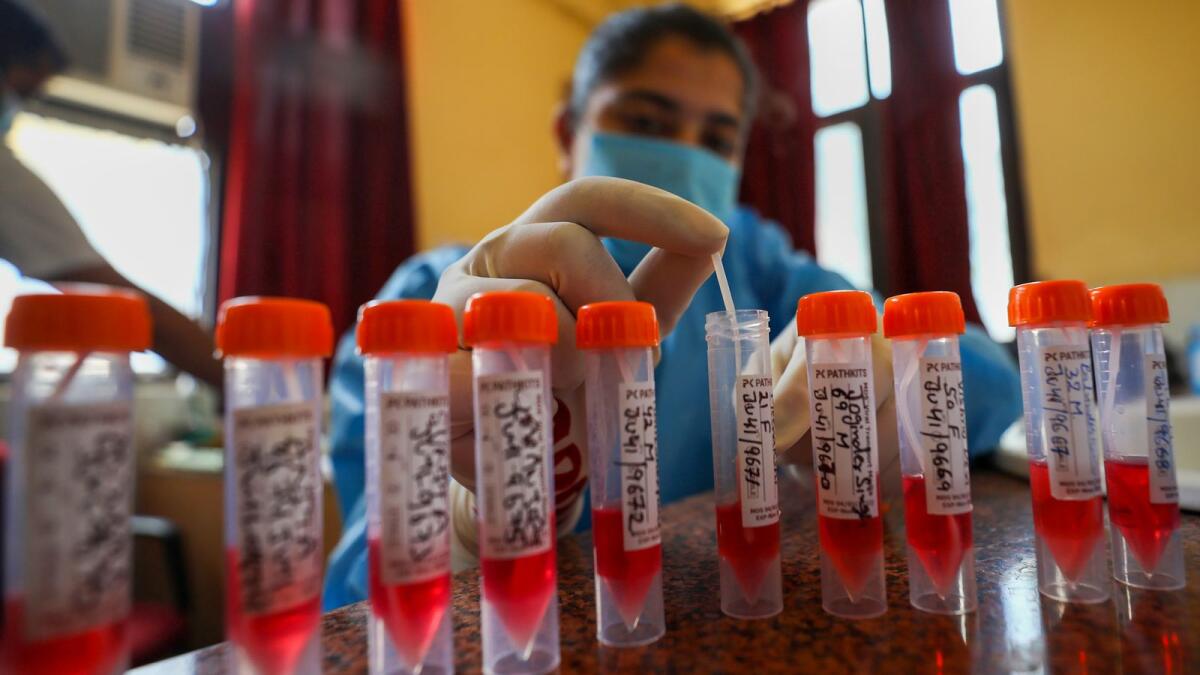A healthcare worker collects swab samples for Covid-19 test, amid a rise in coronavirus cases in the country, in Jammu on Thursday. — PTI