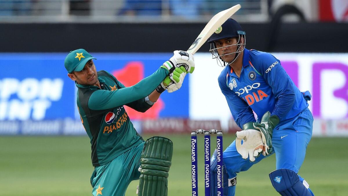 Pakistan's Shoaib Malik plays a shot as Indian wicketkeeper Mahendra Singh Dhoni  looks on during an ODI Asia Cup match in Dubai. — AFP file