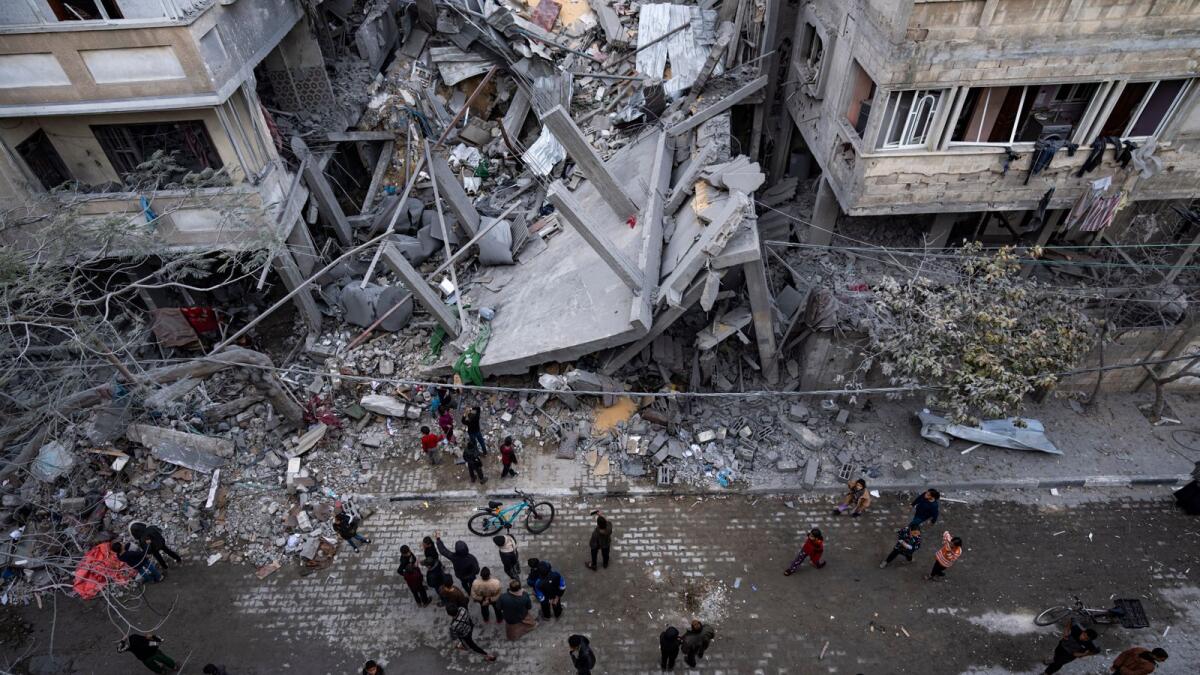 Palestinians inspect the damage of residential buildings after an Israeli airstrike in Rafah. — AP