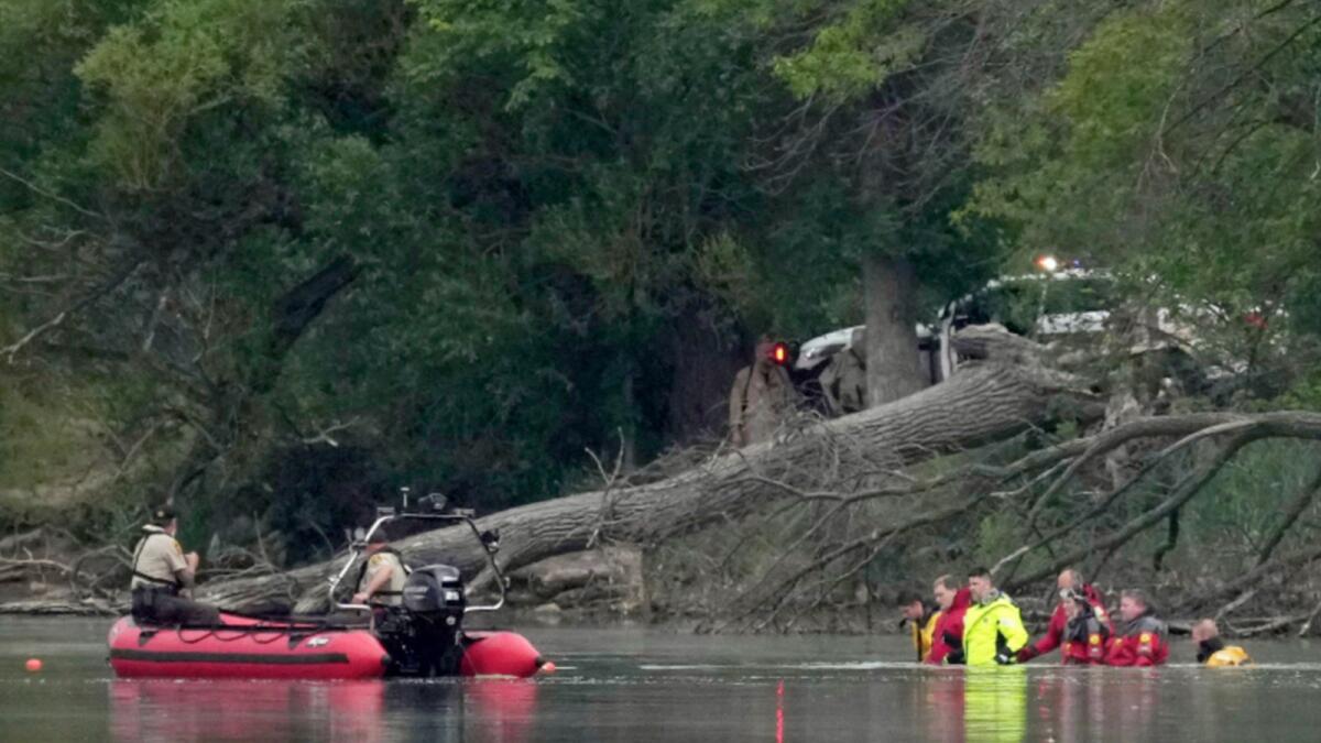Teams in dry suits and Ramsey County Sheriff's deputies search for the bodies of a mother and her three children at Vadnais Lake. — AP