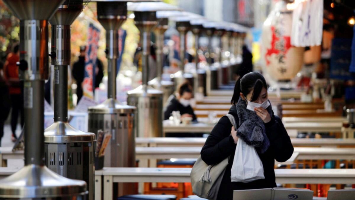 A woman wearing a face mask is seen at an open-air restaurant in Tokyo, Japan. — Reuters