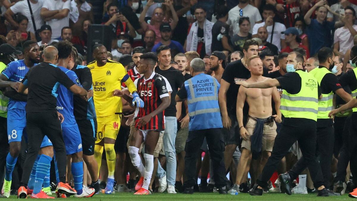 Fans try to invade the pitch during the French League match between OGC Nice and Olympique de Marseille. — AFP