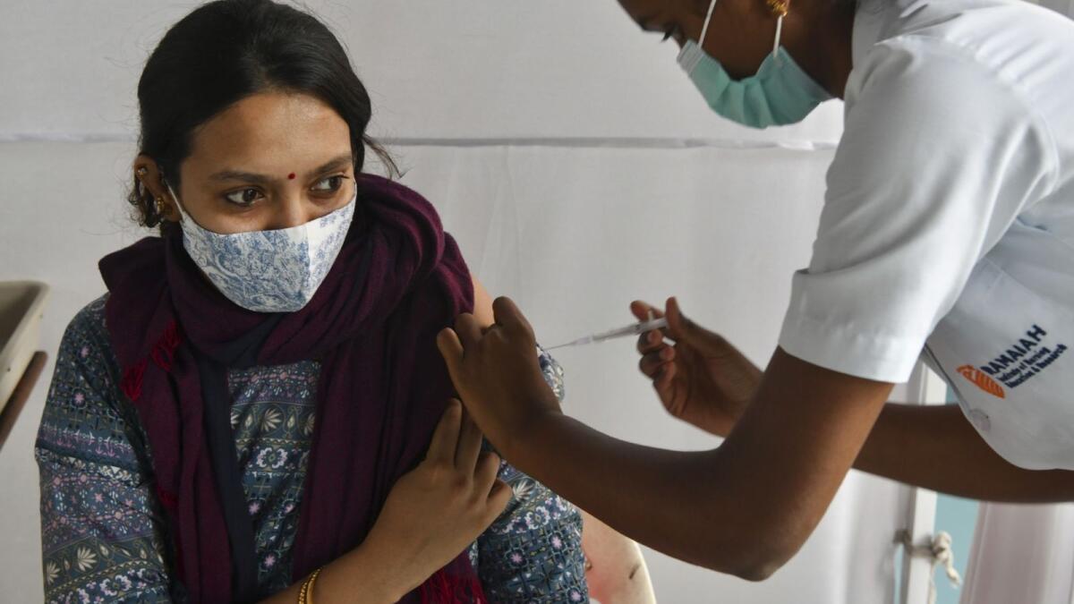 A medical staff inoculates a woman with a dose of the Covishield vaccine against Covid-19 coronavirus disease at the Ramaiah Hospital in Bangalore on October 21, 2021, as India administered its billionth Covid-19 vaccine dose on October 21, according to the health ministry, half a year after a devastating surge in cases brought the health system close to collapse. (Photo by Manjunath Kiran / AFP)