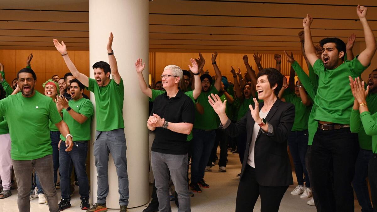 Apple employees cheer next to Chief Executive Officer of Apple Tim Cook (C) and Apple's Senior Vice President of Retail and People Deirdre O'Brien (2R) gestures during the opening of an Apple retail store at a mall in New Delhi on Thursday.  - AFP
