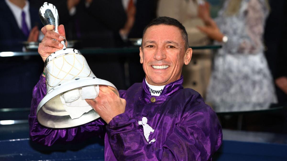 Frankie Dettori celebrates with a trophy after winning the Champion Stakes, his last race in Britain. - Reuters