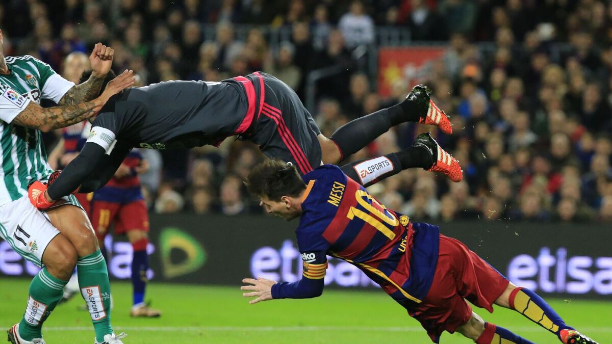 Real Betis’ goalkeeper Antonio Adan (up) hits Barcelona’s Lionel Messi during the Spanish league late on Wednesday. 