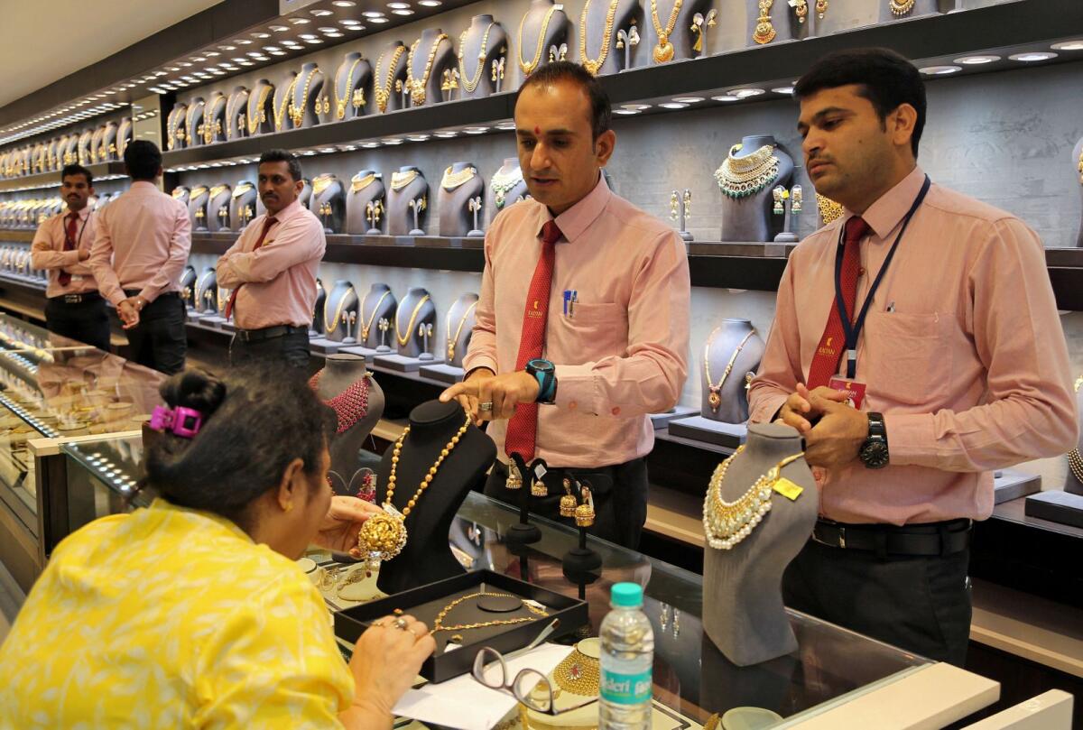 FILE PHOTO: A customer checks a gold necklace before buying it inside a jewellery showroom. Photo: Reuters