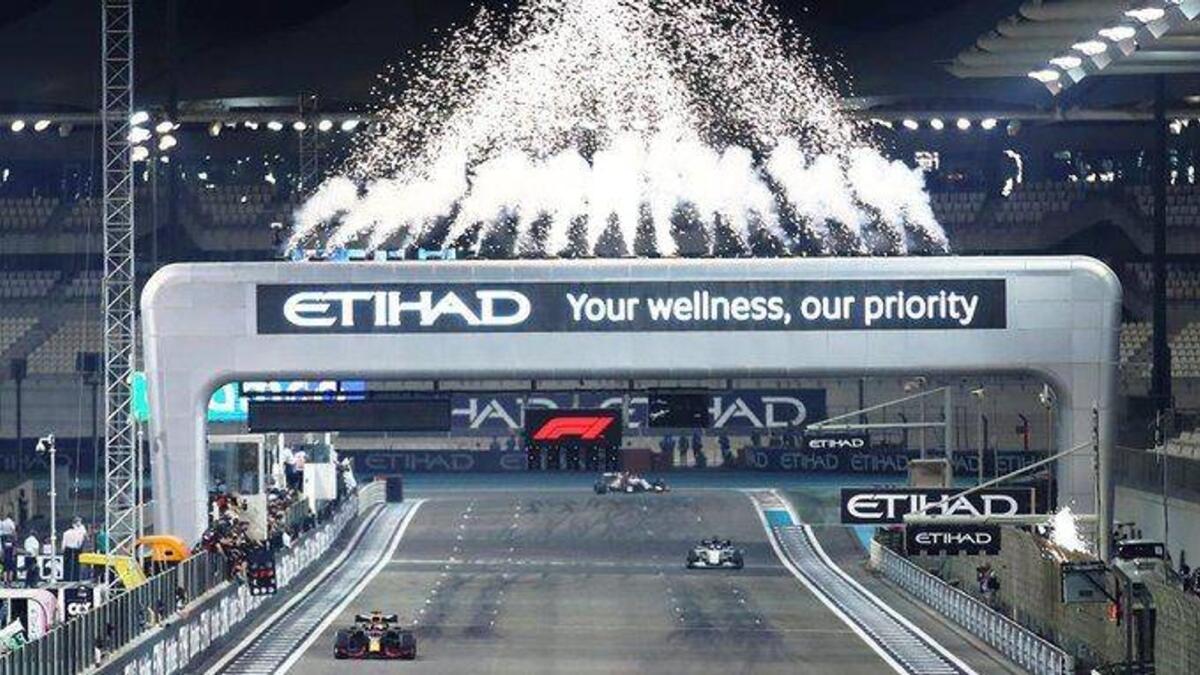 Red Bull Racing's Max Verstappen takes the chequered flag at the Yas Marina Circuit to win the Formula One Etihad Airways Abu Dhabi Grand Prix on Sunday. — Aston Martin Red Bull Racing Twitter