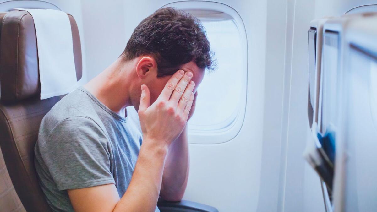 headache in the airplane, man passenger afraid and feeling bad during the flight in plane