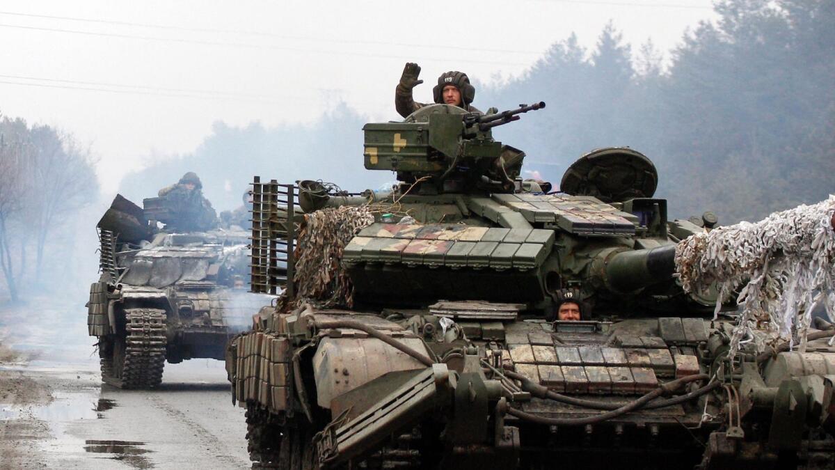 Ukrainian servicemen ride on tanks towards the front line with Russian forces (AFP)