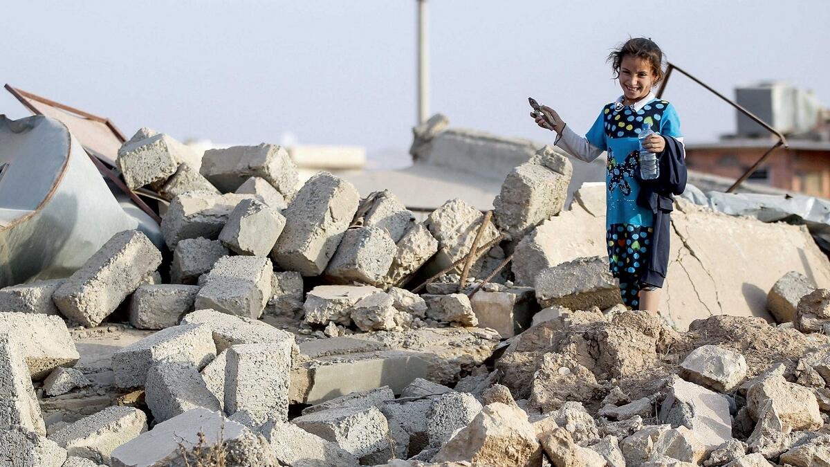Children escaping Raqqa, Syria, could take decades to overcome the psychological wounds inflicted by Daesh. Here, an Iraqi girl stands on the rubble of her home in northwest of Mosul. — AFP Photo