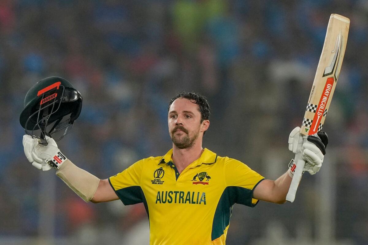 Australia's Travis Head raises his bat as he celebrates after scoring a century. — AP