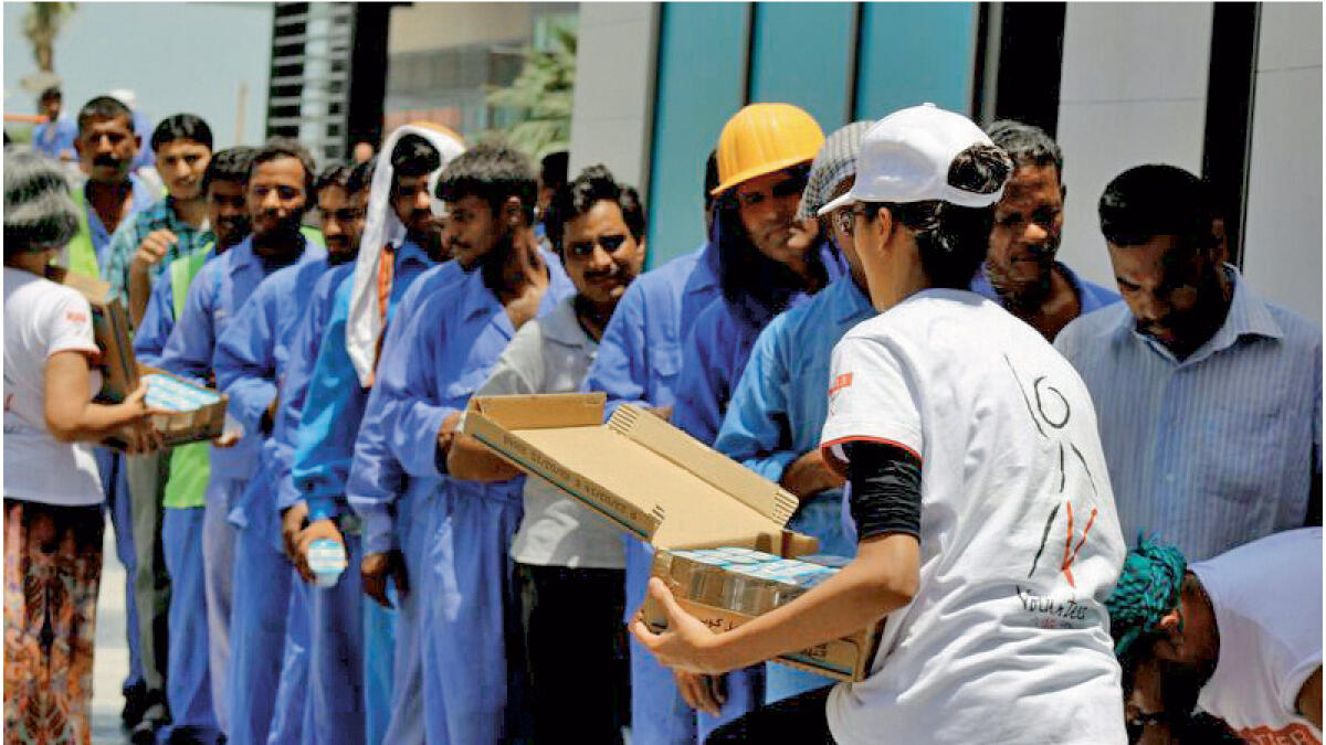 Saima and team giving out free water bottles and refreshments to labourers at a construction site in JBR.