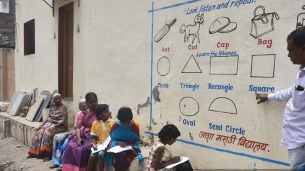 Indian school paints village walls for outdoor pandemic classes. - AFP