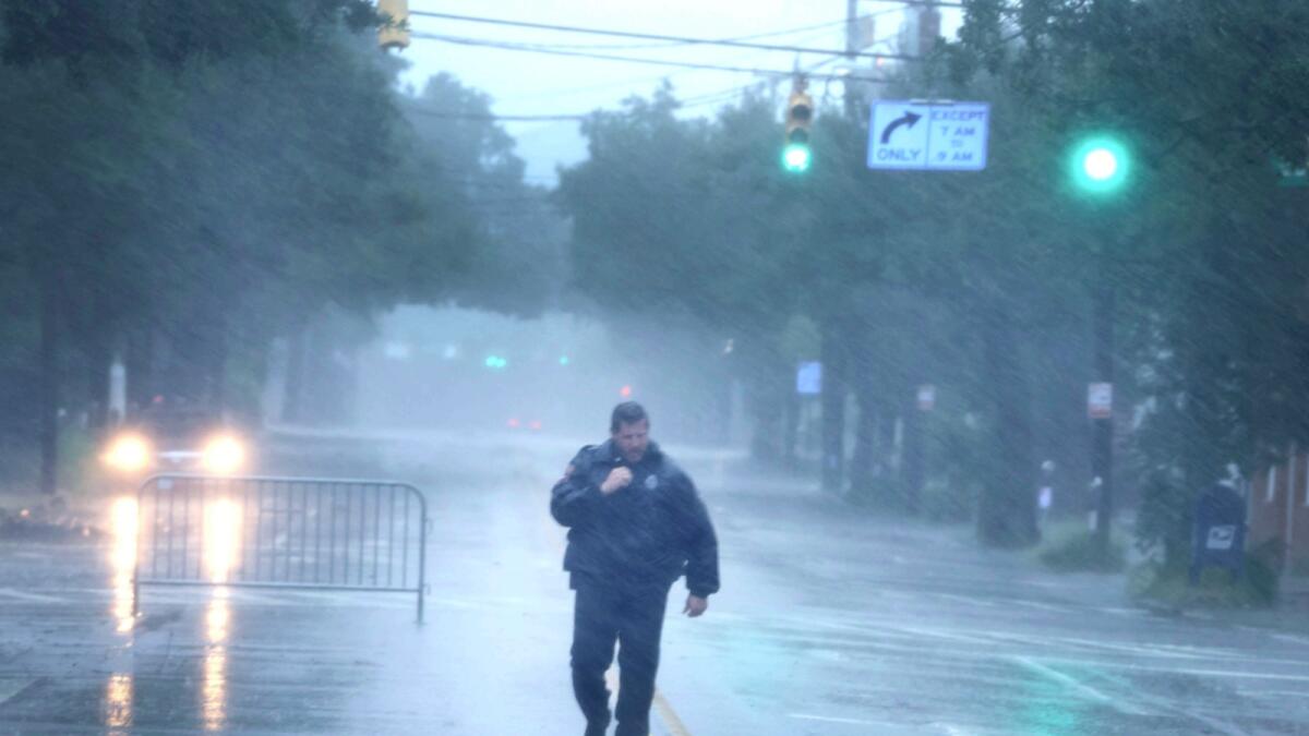 A police officer walks down a street as rain from Hurricane Ian begins to cause flooding in Charleston, South Carolina. — AFP