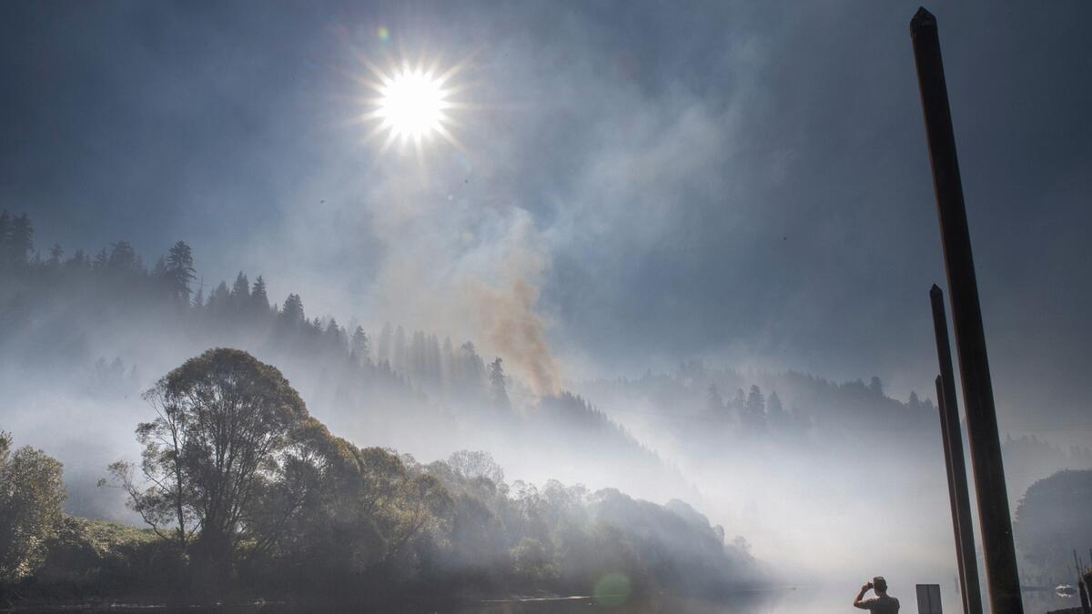 Smoke hangs over the Siuslaw River near Mapleton, Ore., as the The Sweet Creek Milepost 2 Fire burns on the hillside overlooking the town. Photo: AP