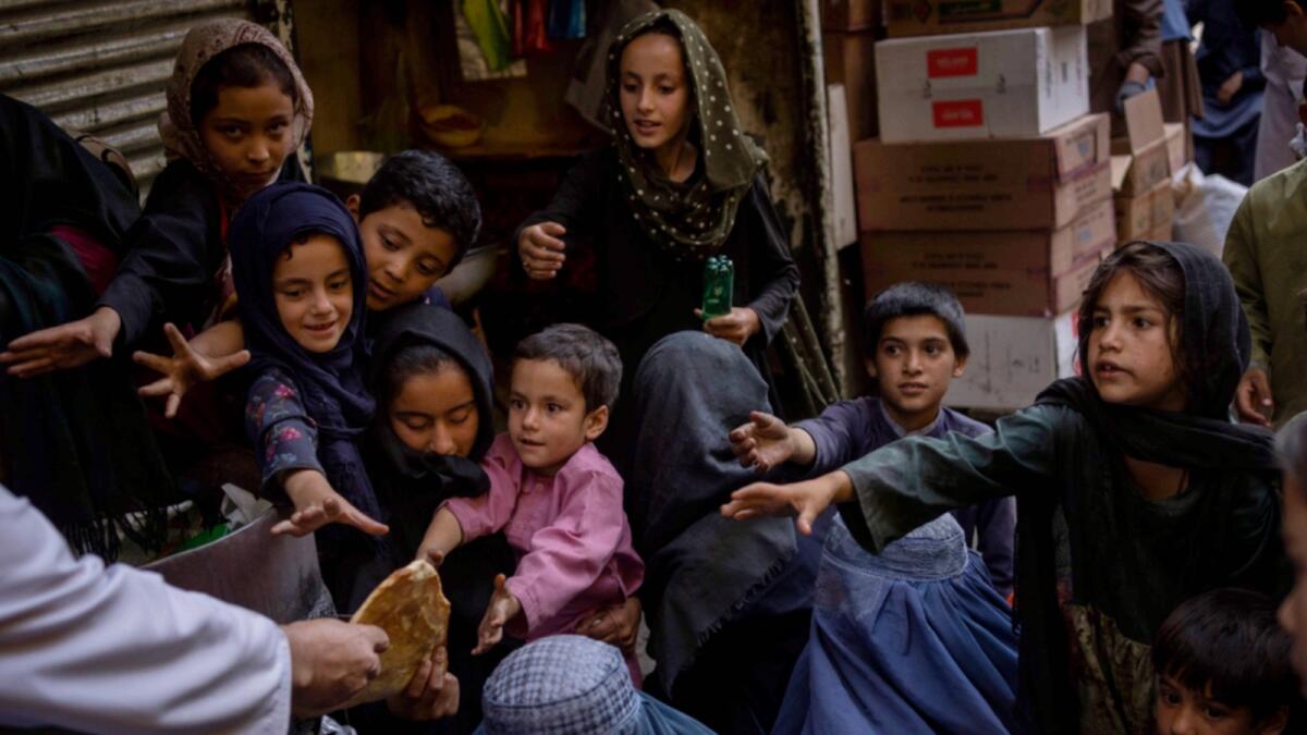 Afghan women and children receive bread donations in Kabul's Old City. — AP