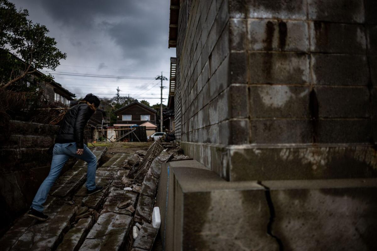 This picture taken on January 6, 2024 shows Masaki Sato, who has owned an 85-year-old property in the area since 2017 and runs it as a summer B&amp;B, walking in Akasaki village, Ishikawa prefecture after a major 7.5 magnitude earthquake struck the Noto region on New Year's Day.  — AFP