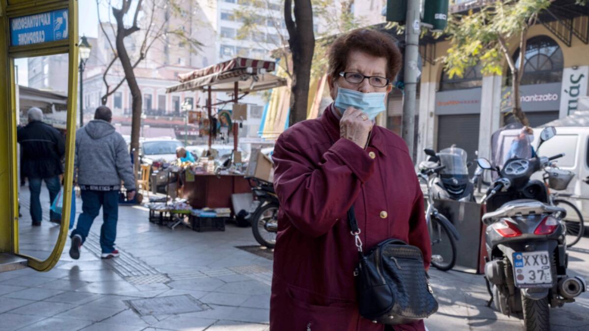 An elderly woman wearing a face mask to curb the spread of coronavirus, walks in central Athens. — AP