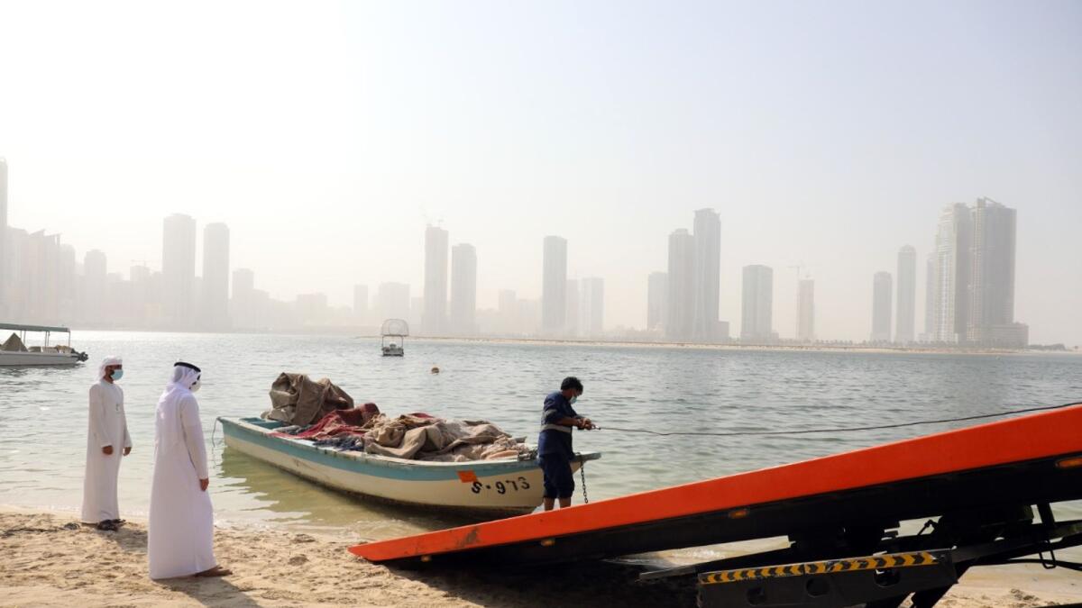 Sharjah Municipality officials oversee the removal of abandoned boats.